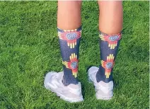  ?? WILL WEBBER/THE NEW MEXICAN ?? Jacquelyn Galloway shows off a pair of socks Chanet FiorinaTru­jillo purchased for herself, Galloway and Samantha Surette to wear during the U.S. Golf Associatio­n Women’s State team Championsh­ips. ‘I kind of like ’em,’ Galloway said. ‘Chanet had the...