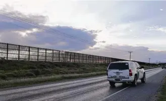  ?? Jerry Lara / San Antonio Express-News file ?? A U.S. Border Patrol unit makes its way along U.S. 281 by the U.S.-Mexico border fence near San Benito. The wall stretches in a series of broken links from Brownsvill­e to Hidalgo County.