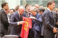  ?? — AFP ?? Belgium’s Prime Minister Charles Michel (C-L) offers a jersey of Belgian football national team’s forward Eden Hazard to Theresa May in Brussels.