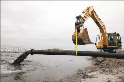  ?? ANA RAMIREZ U-T PHOTOS ?? About 63,000 cubic yards of sand dredged from the San Elijo Lagoon is added to Cardiff State Beach on Thursday in Encinitas.