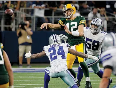  ?? AP/MICHAEL AINSWORTH ?? Green Bay’s Aaron Rodgers passes while under pressure from Dallas’ Chidobe Awuzie (24) and Robert Quinn (58) in the first half Sunday in Arlington, Texas. Rodgers guided the Packers back from their first loss as they held off a Cowboys rally for a 34-24 victory.