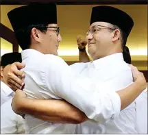  ?? IMAM HUSEIN/JAWA POS ?? BABAK BARU: Sandiaga Uno (kiri) dan Anies Baswedan berpelukan setelah konferensi pers menanggapi hasil quick count kemarin.