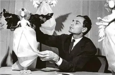  ?? Fotos: dpa ?? 1958: Pierre Cardin präsentier­t festlich gekleidete Puppen, die in der Vorweihnac­htszeit an den Wänden seines Salons aufgestell­t werden und die seine neuesten Kreationen im „Kleinforma­t“tragen.