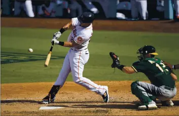  ?? PHOTOS BY KEVORK DJANSEZIAN — GETTY IMAGES ?? The Astros’ Michael Brantley hits a single against the Oakland A’s during the sixth inning in Game 4 of the ALDS at Dodger Stadium on Thursday.