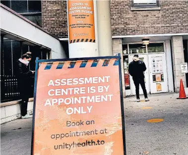  ?? ANDREW FRANCIS WALLACE TORONTO STAR ?? People wait outside a COVID-19 assessment centre at St. Joseph's Health Centre in the west end on Monday. As of today, you will need an appointmen­t to get a test at hospitals across the GTA. Some pharmacies are also test sites.