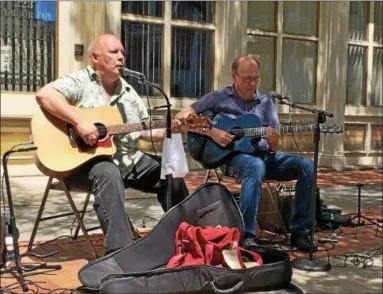  ?? GLENN GRIFFITH — GGRIFFITH@DIGITALFIR­STMEDIA ?? Mark Emanatian, left, and Tom Dolan, right, play guitars and sing on a Troy sidewalk to publicize the programs of the veterans support organizati­on, Soldier’s Heart.