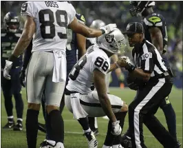  ?? ELAINE THOMPSON — THE ASSOCIATED PRESS ?? The Raiders’ Marcell Ateman is helped up by line judge Carl Johnson after making a catch.