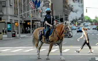  ?? AP ?? A New York police officer patrols near Times Square yesterday.