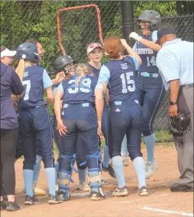  ?? DOUG HASTINGS PHOT ?? Wilmington’s Sofia Scalfani (far right) is greeted at home plate after crushing a home run, but the Wildcats were eliminated by Wakefield in a wild 12-11 softball game.