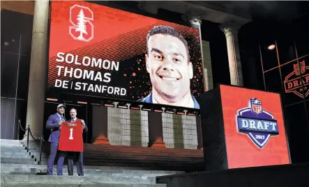  ?? Elsa / Getty Images ?? Stanford’s Solomon Thomas has his name and face in lights as he poses with NFL Commission­er Roger Goodell.