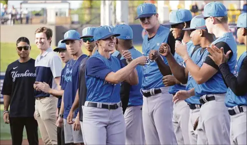  ?? Phelan M. Ebenhack / Associated Press ?? Tampa Tarpons manager Rachel Balkovec, center, exchanges fist bumps with her players while making her debut as a minor league manager on Friday night.