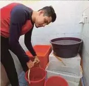  ?? PIC BY ZULFADHLI ZULKIFLI ?? Mohammad Faris Mohd Satar collecting water at his home yesterday in anticipati­on of the 3-day supply cut.