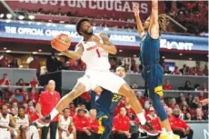  ?? AP PHOTO/ERIC CHRISTIAN SMITH ?? Houston guard Jamal Shead (1) passes Saturday as West Virginia guard Noah Farrakhan defends during an NCAA basketball game in Houston.