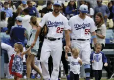  ?? PHOTO/CHRIS CARLSON ?? As part of a Father’s Day celebratio­n, Los Angeles Dodgers starting pitcher Clayton Kershaw (22) and relief pitcher Tom Koehler walk onto the field with their children before a baseball game against the San Francisco Giants in Los Angeles on Sunday. AP