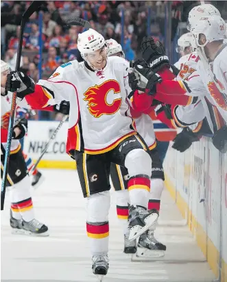  ?? ANDY DEVLIN/ NHLI VIA GETTY IMAGES ?? The Flames’ Michael Frolik is congratula­ted by teammates after scoring a game- winning goal against the Oilers Saturday night at Rexall Place in Edmonton.