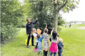  ??  ?? Lots of interest Chris Martin from the council’s community greenspace team shows some of the children one of the bird boxes in its new home