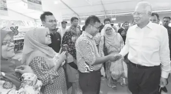  ??  ?? Prime Minister Datuk Seri Najib Tun Razak greeting the public during his visit to the MyFarm Outlet Kasih at Precinct 7, Putrajaya. MyFarm Outlet sells local produce straight from the farm selling at 5-20 percent cheaper than other outlets. - Bernama...