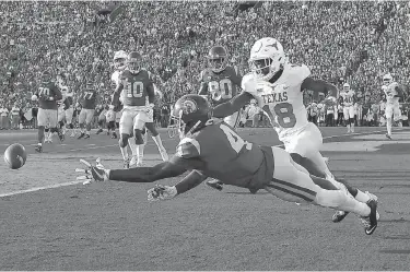  ?? Associated Press ?? n Southern California wide receiver Steven Mitchell Jr., left, can't reach a pass intended for him while under pressure from Texas defensive back Davante Davis during the first half of an NCAA college football game Saturday in Los Angeles.