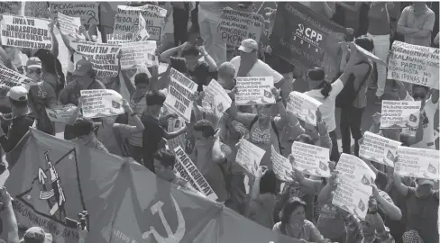  ?? AP ?? Nearly 100 members and supporters of the undergroun­d Communist Party of the Philippine­s display placards during a “lightning rally” on Friday near the Presidenti­al Palace in Manila in a show of force a few days before the resumption of peace talks with...