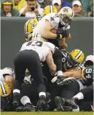  ?? Jeffrey Phelps / Associated Press ?? New Orleans QB Drew Brees dives over the pile for a second-half TD.