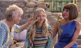  ?? Universal Pictures ?? Sophie (Amanda Seyfried) takes on grown-up responsibi­lities in the “Mamma Mia!” sequel, with help from her mom’s friends Rosie (Julie Walters, left) and Tanya (Christine Baranski).