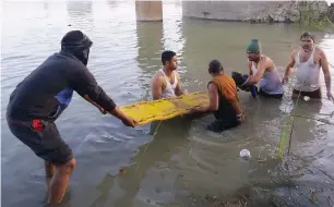  ?? AFP ?? Rescuers recover the body of a child from the Banas River in Rajasthan on Saturday. —