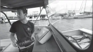  ?? STEVEN SENNE, THE ASSOCIATED PRESS ?? Frank Marino, an engineer with Sea Machines Robotics, controls a self-driving boat remotely.