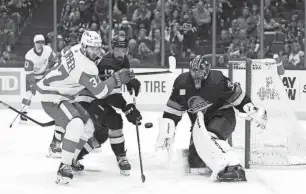  ?? BOB FRID/USA TODAY SPORTS ?? Red Wings forward J.T. Compher, left, and Canucks defenseman and former Red Wing Filip Hronek follow a rebound in the first period Thursday.