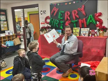  ?? ?? Special Education Teacher Toby Koeth reads to a group of youngsters.