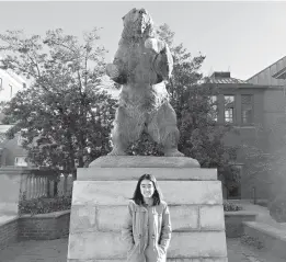  ??  ?? Teresa Conchas, who graduated earlier this year from Young Women’s Leadership Academy as valedictor­ian, stands in front of a statue of Bruno the bear on the main at Brown University in Rhode Island.