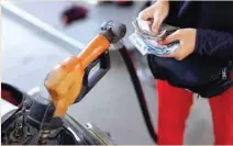 ?? — Reuters ?? A worker at Pertamina petrol station holds money as a motorcycle is filled with subsidised fuel in Jakarta, Indonesia.