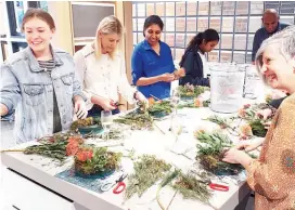  ??  ?? Metricon guests getting creative and designing their own festive wreaths.