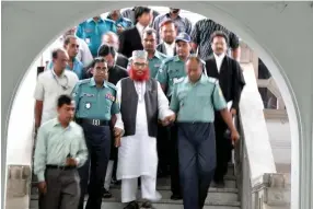  ??  ?? Jamaat-e-Islami preacher Delwar Hossain Sayeedi, center, is escorted by policemen outside a court in Dhaka in this file photo. (AFP)