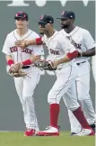  ?? MARY SCHWALM / BOSTON HERALD ?? WELL DONE: Mookie Betts, center, pats Andrew Benintendi on the chest as they celebrate an August win over the New York Yankees with Jackie Bradley Jr.