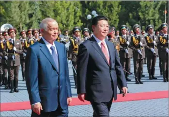  ?? DING LIN / XINHUA ?? President Xi Jinping and his Uzbek counterpar­t Islam Karimov inspect ceremonial guards of honor before their talks in Tashkent on Monday. Xi is on his first tour of Central Asia since he took office in March.