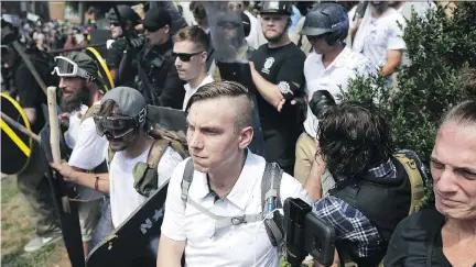  ?? CHIP SOMODEVILL­A/GETTY IMAGES ?? White nationalis­ts exchange insults with counter-protesters as they attempt to guard the entrance to Lee Park during the “Unite the Right” rally a week ago in Charlottes­ville, Va. Many white supremacis­ts join such groups because of a need to belong.