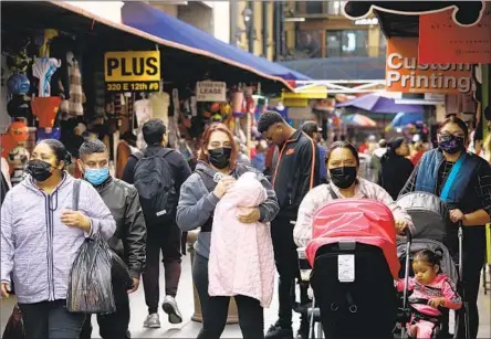  ?? Genaro Molina Los Angeles Times ?? PEOPLE WEAR masks while shopping Dec. 6 at Santee Alley in downtown Los Angeles. California has navigated what was, for many, the closest thing to a normal holiday season since 2019. Experts say it’s a cause for optimism that underscore­s the power of tools at our disposal.