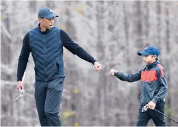  ?? PHELAN M. EBENHACK/AP ?? Tiger Woods gives his son Charlie a fist bump after Charlie made a putt during a practice round ahead of the PNC Championsh­ip onThursday.