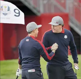  ?? David J. Phillip Associated Press ?? PHIL MICKELSON, right, celebrates with Rickie Fowler, who chipped in on the ninth hole at Hazeltine to help the U.S. team win its alternate-shot match.