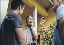  ?? Maria Alejandra Cardona Los Angeles Times ?? WEN LOU, center, speaks to congressio­nal candidate Gil Cisneros, right, and a campaign staffer Sunday. Lou, 71, said he has already voted for the Democrat.