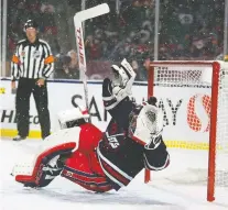  ?? TROY FLEECE ?? Winnipeg Jets goaltender Connor Hellebuyck takes a tumble during Saturday’s NHL Heritage Classic against the Calgary Flames on Saturday at Mosaic Stadium.