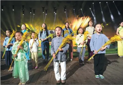  ?? PHOTOS PROVIDED TO CHINA DAILY ?? Children hold wheat in the live show On the Liuyang River to symbolize the prosperous future of Liuyang River on June 27.