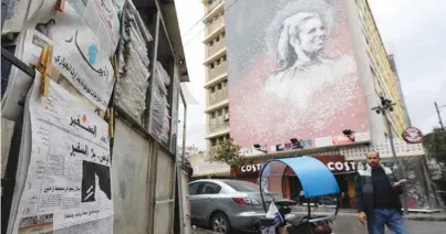  ??  ?? BEIRUT: A man walks past a newspaper stand, displaying the As-Safir newspaper, in Beirut’s Hamra neighborho­od yesterday. —AFP