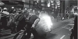  ?? BILLY H.C. KWOK/GETTY ?? Protesters push a burning cart toward police during a demonstrat­ion in Hong Kong.