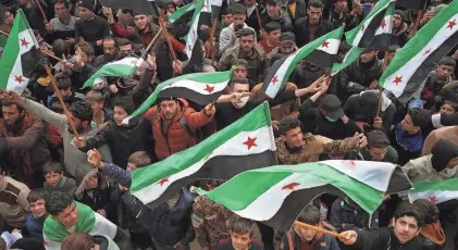  ?? AAREF WATAD/AFP VIA GETTY IMAGES ?? Syrians mark 13 years since pro-democracy protests swept the country, in the rebel-held city of Idlib on Friday. Government suppressio­n of the uprising set off a civil war that has killed more than half a million people.