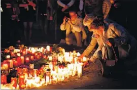  ?? Ina Fassbender Getty Images ?? PEOPLE light candles at the scene where two people were killed and 20 others injured after a man drove a van into a crowd on Saturday in Muenster, Germany.
