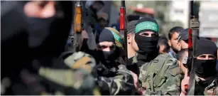  ?? (Ibraheem Abu Mustafa/Reuters) ?? HAMAS MEMBERS march during a funeral in the Gaza Strip last month.