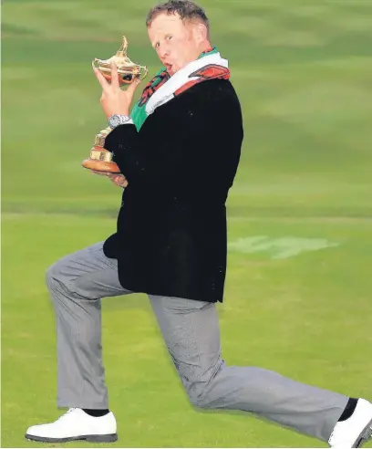  ??  ?? ●● Jamie Donaldson with the cherished Ryder Cup after his win over Keegan Bradley ensured Europe would keep the trophy for another two years
