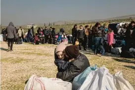  ?? NICOLE TUNG/THE NEW YORK TIMES ?? People wait to return to Syria from Turkey on Wednesday at the Cilvegozu border crossing after Syrian border officials announced a Turkish policy change.