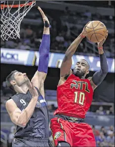  ?? REINHOLD MATAY / AP ?? Center Nikola Vucevic (left, defending against Hawks guard Tim Hardaway Jr.) had 16 points and 14 rebounds Saturday in the Magic’s 105-86 win.